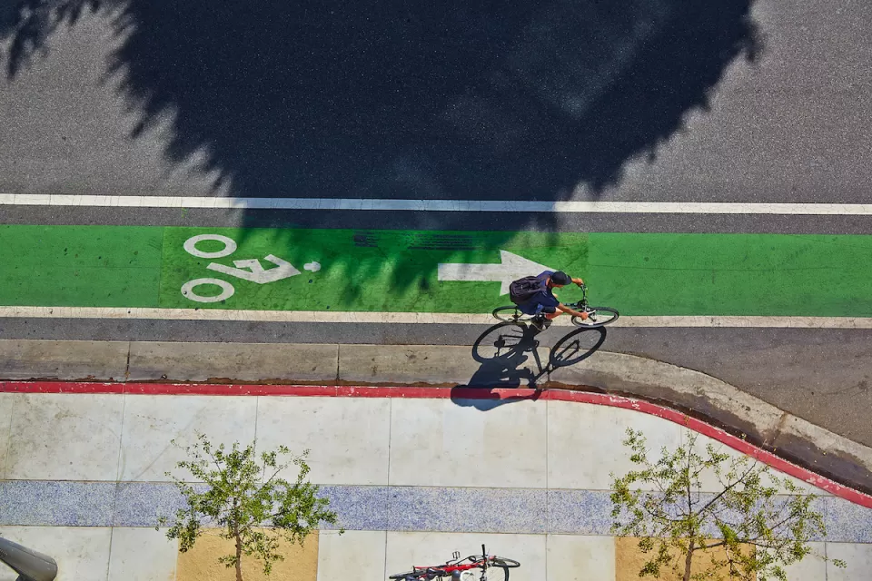 Bird's eye view of green painted bike lane with one cyclist.